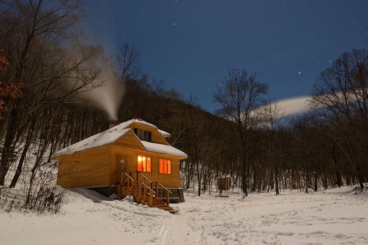 Small, rural cabin with lights on in the dark